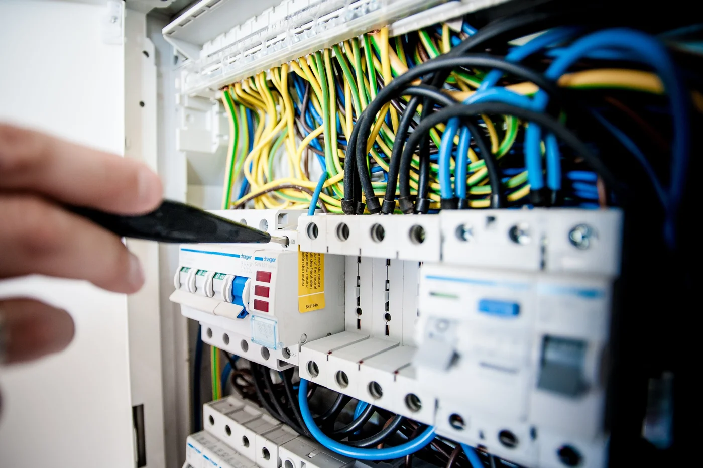 Electrician working on circuit breakers and wiring in an electrical panel