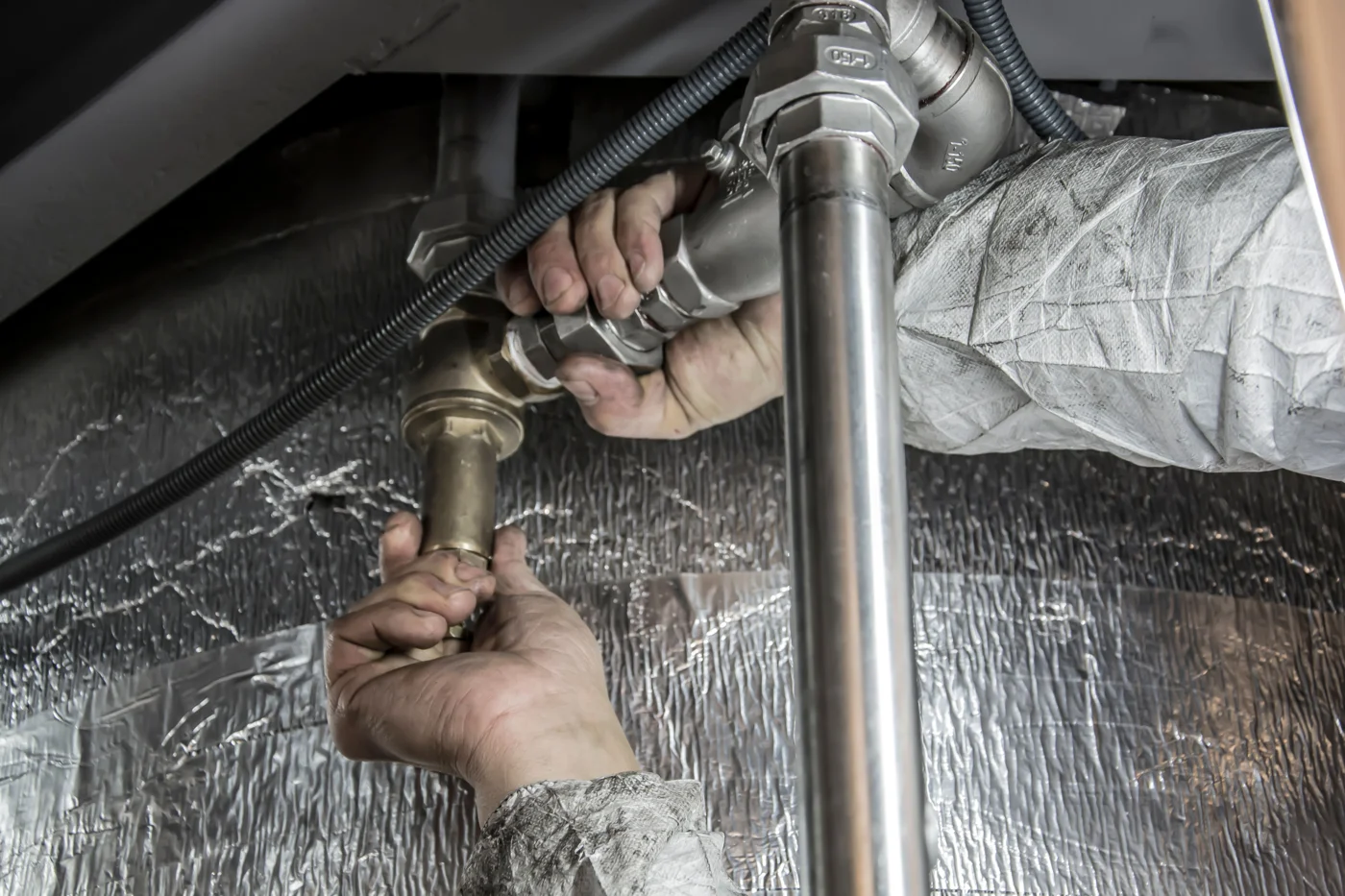 Plumber fitting metal pipes with hand tools