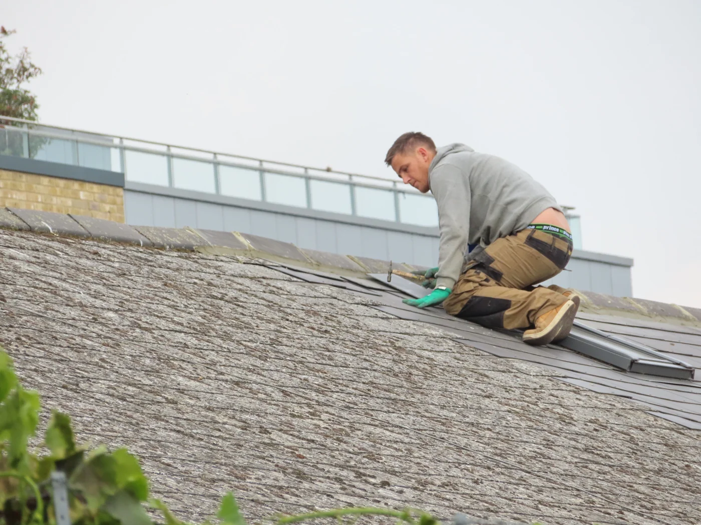 hata-roofing-trade-photo Roofer fitting roof tiles on a sloped roof